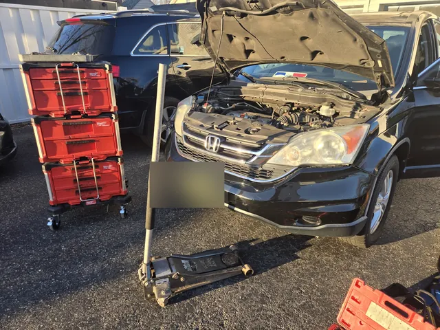 Honda CR-V repair at the curb, tool cases and jack ready